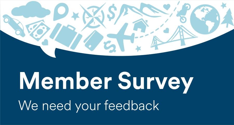 A couple drives down a scenic road, overlaid text reads "Your next adventure starts at Alaska Air Group Credit Union. Auto loans as low as 4.74% APR* *On approval of credit, restrictions apply." 